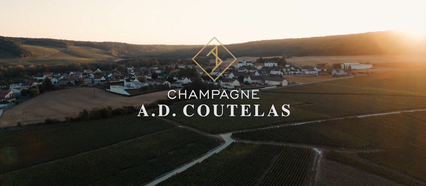 Logo dello champagne A.D. Coutelas e sullo sfondo un panorama della regione dello Champagne in Francia