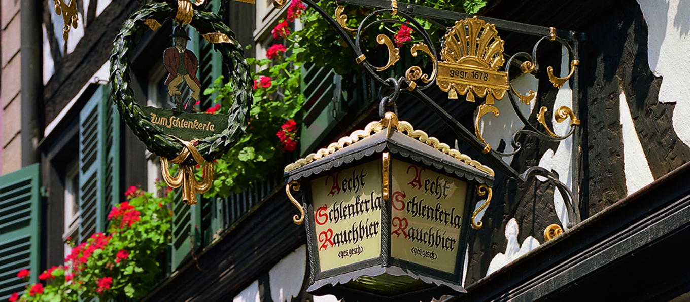 Insegna della birreria Schlenkerla installata sulla facciata del palazzo nel centro di Bamberga. | Topbeer