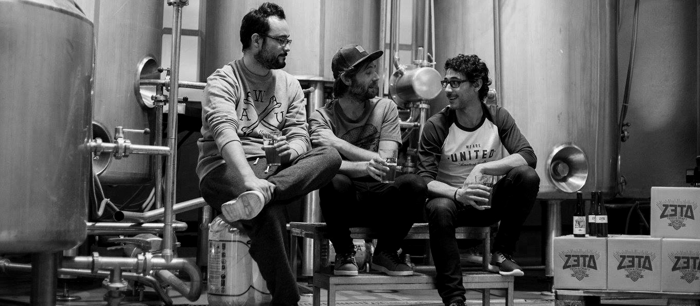 I tre soci del birrificio spagnolo Zeta parlano davanti all'impianto bevendo birra | Topbeer